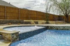 MS-886-in-spa-and-spill-over-IS-637-waterline-Scabos-Coping-and-2x4-Splitface-by-Grotto-Pools.2-scaled