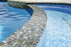 MS-886-in-spa-and-spill-over-IS-637-waterline-Scabos-Coping-and-2x4-Splitface-by-Grotto-Pools.7-scaled